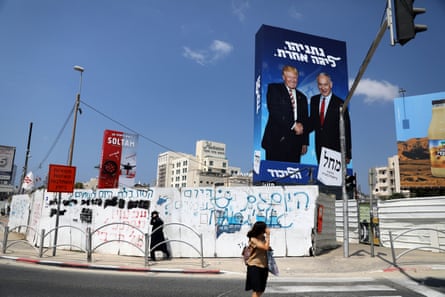 Pedestrians walk next to a Likud party election campaign banner in Bnei Brak, Israel in September.