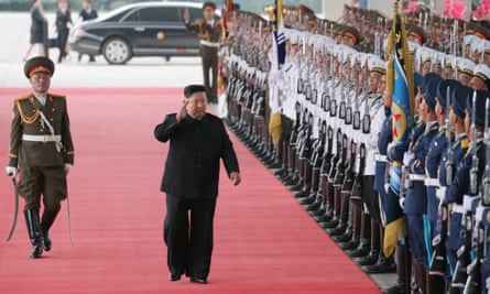 Kim Jong-un walks along waving at a processionary guard