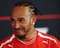 Lewis Hamilton smiles during a press conference.