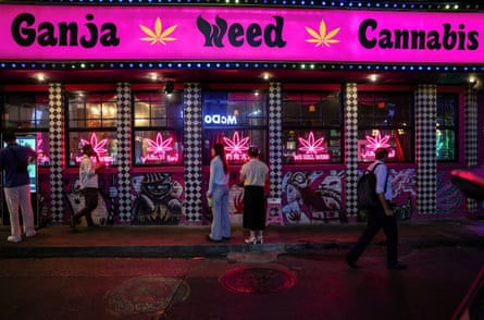People walk past a cannabis shop on Sukhumvit Road in Bangkok