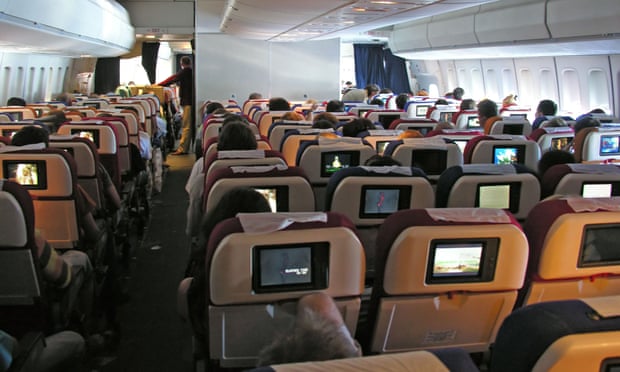 An aircraft cabin with TV screens