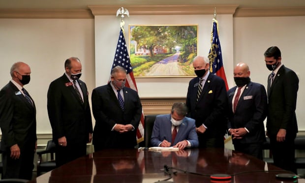 Republican governor of Georgia, Brian Kemp, signs the restrictive voting law on 25 March 2021. 