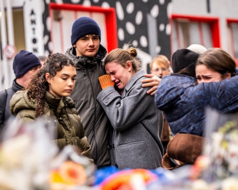 Mourners gather near Le Constellation