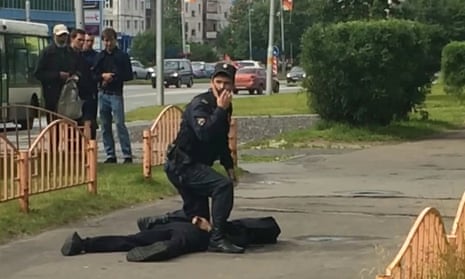 A Russian policeman stands over the suspected attacker in Surgut, Siberia.
