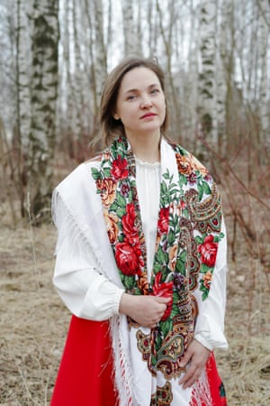 Vera posing for a photo in front of a wooded area