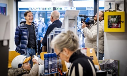Mark Rutte talks to a journalist in a shop
