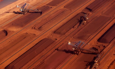 Stackers operate next to stockpiles of iron ore at the processing facility at Andrew Forrest’s Fortescue Metals Group in Port Hedland in the Pilbara region, Western Australia.