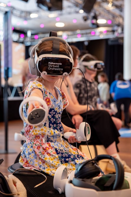 A young girl with VR headset and controllers plays in the virtual orchestra