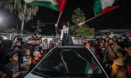 Palestinians celebrate news of a ceasefire agreement with Israel in Deir al Balah.