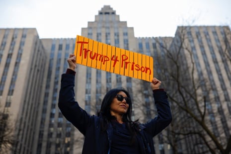 An anti-Trump protester holds a sign outside Manhattan Criminal Courthouse saying Trump 4 prison