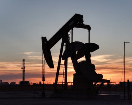 A drone view of a pump jack and drilling rig south of Midland, Texas.