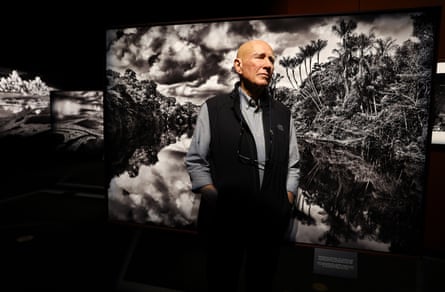 man standing in front of artwork puts hands in pockets and looks to side