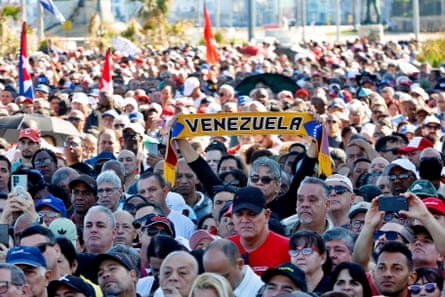 A person holds up a Venezuela scarf amid the crowd of people
