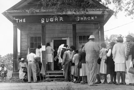 African American voters, able to vote for the first time in rural Wilcox County, Alabama, line up in front of a polling station at The Sugar Shack, a local general store. After the passage of the federal voting rights law in 1965, there were almost twice as many black voters than whites.