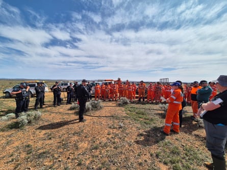 Emergency services personnel gathered in scrubby desert
