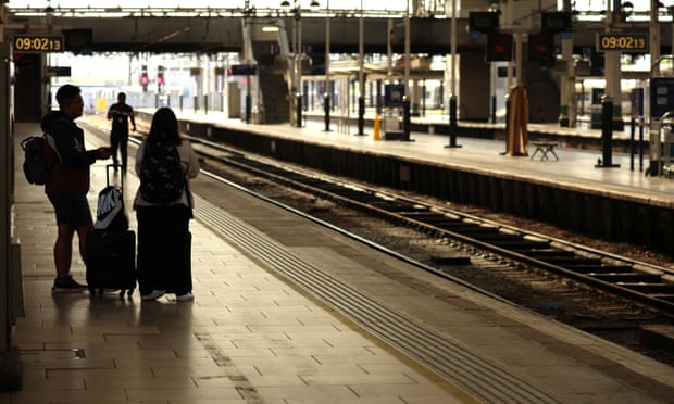 People wait on an empty platform on the first day of a national rail strike at Manchester Piccadilly station