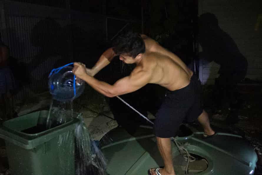 A refugee pulls water from a makeshift well inside the Manus Island detention centre.