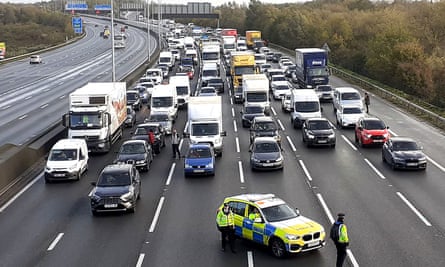 Police halt traffic on the M25 in November 2022 after climate activists scaled overhead gantries.