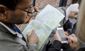 A man checks a map of Sweden after arriving at Malmo train station in Sweden in September; others have refused to leave a bus close to the Norwegian border due to the cold.