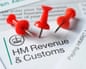 The HMRC letterhead and logo on a letter, stuck with red noticeboard pins.