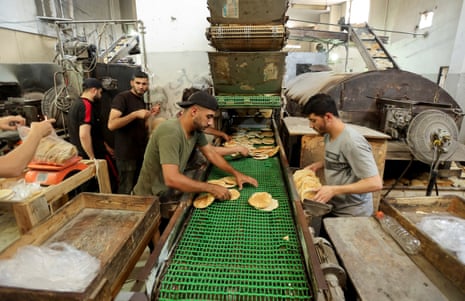 Palestinian workers make bread in a bakery that returned to operation after being closed due to a flour shortage, in Deir Al-Balah, in the central Gaza Strip, on Thursday.