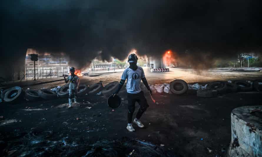 Protesters walk amid smoke near a makeshift barricade in Yangon last year during a military crackdown on anti-coup demonstrations