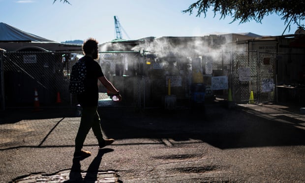 A man enters an encampment outfitted with a misting station