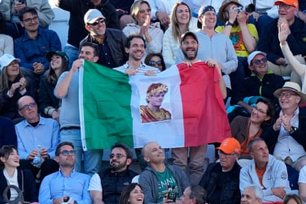 Fans with an Italian flag with an image of Jannik Sinner dressed as an emperor.