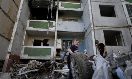 Children stand in front of a building destroyed by attacks in Chernihiv, Ukraine, Sunday, June 19, 2022.