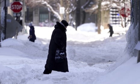 People navigating snowy streets and sidewalks the morning after a snowstorm in the Chicago area, Tuesday, Feb. 16, 2021.