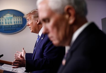 Mike Pence listens as Donald Trump speaks during a coronavirus taskforce briefing at the White House.