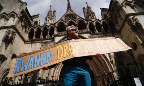 A demonstrator holds a placard during a protest against Britain's Rwanda asylum plan outside the high court in Londo