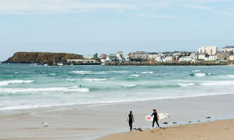 Two female surfers with surfboards walking out to breakers on the West Strand at Portrush, County Antrim, Northern Ireland.<br>AM9J6F Two female surfers with surfboards walking out to breakers on the West Strand at Portrush, County Antrim, Northern Ireland.