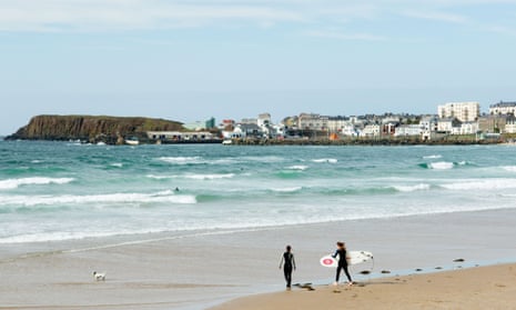 Two female surfers with surfboards walking out to breakers on the West Strand at Portrush, County Antrim, Northern Ireland.AM9J6F Two female surfers with surfboards walking out to breakers on the West Strand at Portrush, County Antrim, Northern Ireland.