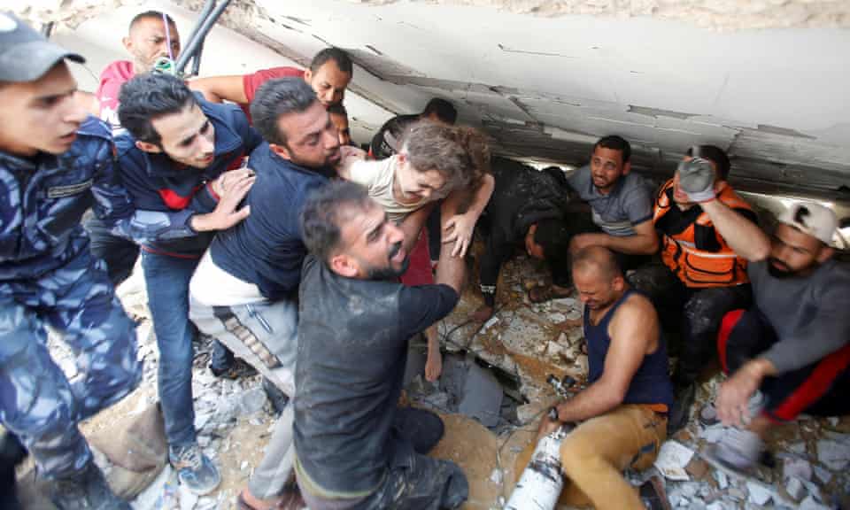 Rescuers carry Suzy Eshkuntana, six, as they pull her from the rubble of a building at the site of an Israeli airstrike in Gaza City.