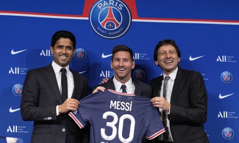 Lionel Messi, center, poses with his jersey with PSG president Nasser Al-Al-Khelaifi, left, and PSG sports director Leonardo during a press conference Wednesday, Aug. 11, 2021 at the Parc des Princes stadium in Paris. Lionel Messi said he's been enjoying his time in Paris "since the first minute" after he signed his Paris Saint-Germain contract on Tuesday night. The 34-year-old Argentina star signed a two-year deal with the option for a third season after leaving Barcelona. (AP Photo/Francois Mori)