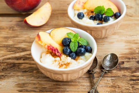 Rice pudding topped with cinnamon, blueberries, peach slices and fresh mint.