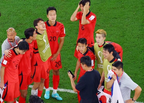 South Korean players wait for the result of the Uruguay match, via a phone.