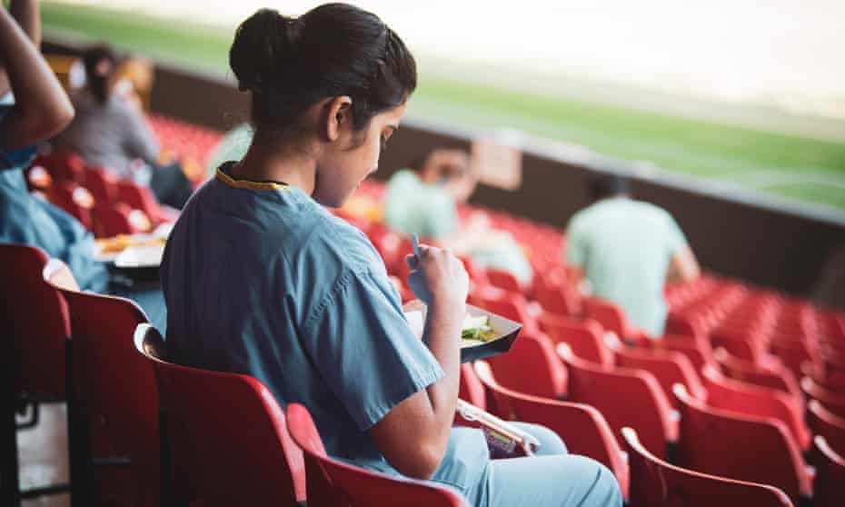 NHS staff eating in the stands at Vicarage Road