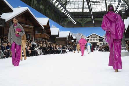 Models in purple waterproofs on the snow-covered catwalk.