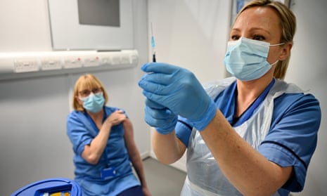 An NHS worker administers the Pfizer BioNTech vaccine at the Louisa Jordan Hospital in Glasgow, Scotland. 