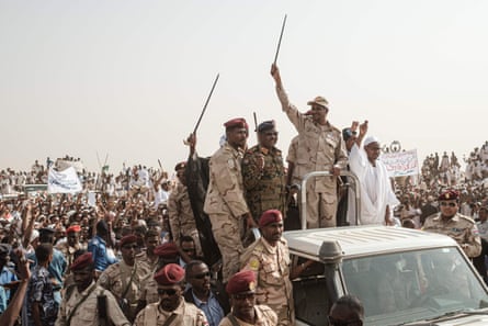 Mohamed Hamdan Dagalo, AKA Hemedti (top, holding up stick) in a village northwest of Khartoum in 2019.