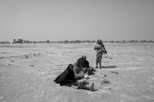 Women wait for food distribution in Toumour refugee camp.