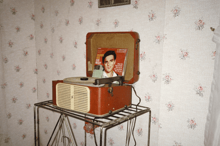 A vintage record player with an Elvis album on it