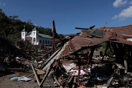 Houses reduced to rubble in the foreground with a church in the background
