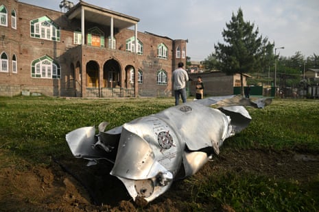 People stand near a part of an aircraft in Wuyan near Indian-administered Kashmir's main city of Srinagar.