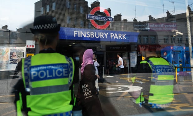 Police officers stand guard outside Finsbury Park tube