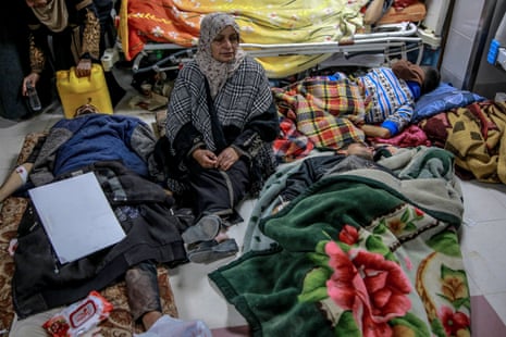 A woman sits among Palestinians at al-Shifa hospital in Gaza City.