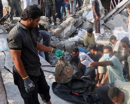 People in Iran search through rubble in the aftermath of an Israeli-US strike