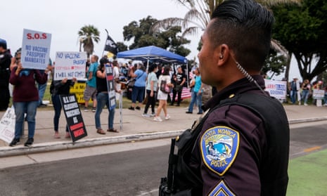 A Santa Monica police officer watches as anti-vaccination protesters take part in a rally against Covid-19 vaccine mandates, in Santa Monica, California, in August.